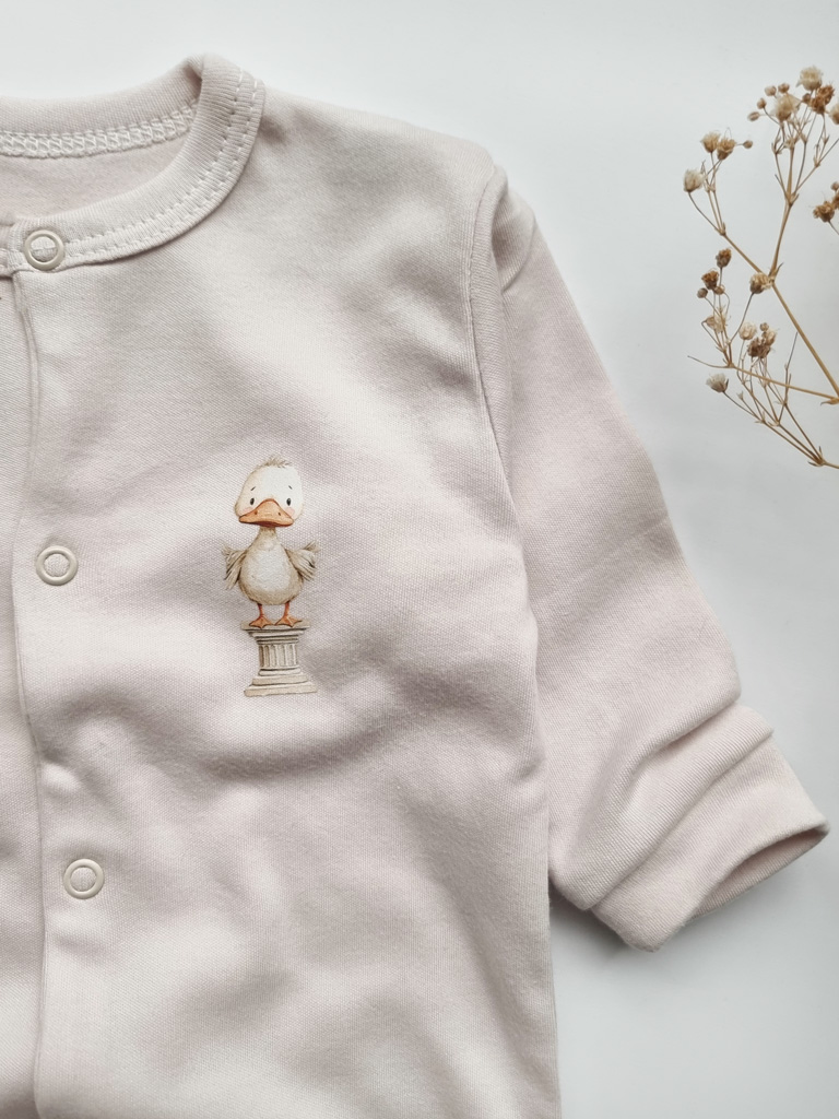 Pajacyk niemowlęcy ze stópkami kaczuszka na kolumnie