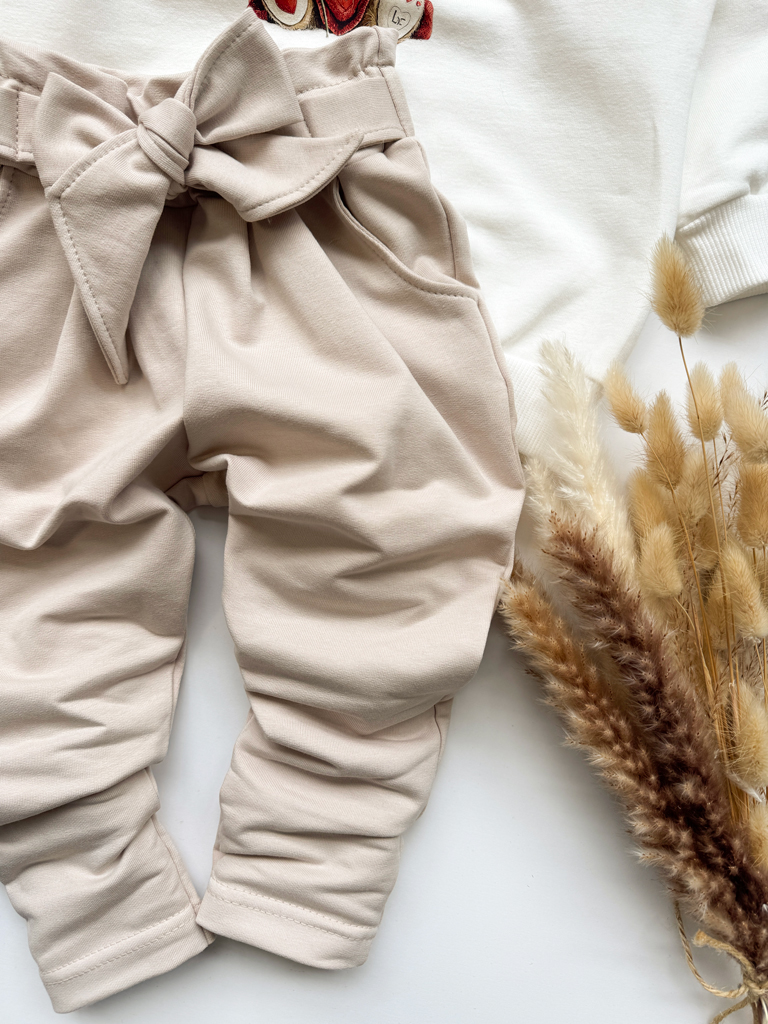 Jasnobeżowe spodnie dla dziewczynki z ozdobnym wiązaniem